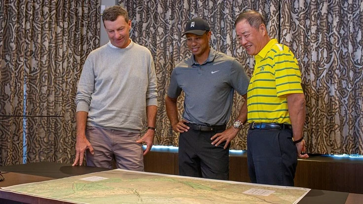 Gil Hanse, left, Tiger Woods, center, and Du Sha study a course layout.