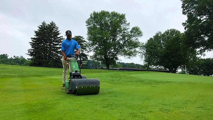 Patapsco High School student Charles Jones Jr. mows an approach during Sparrows Point Country Club member-guest week.