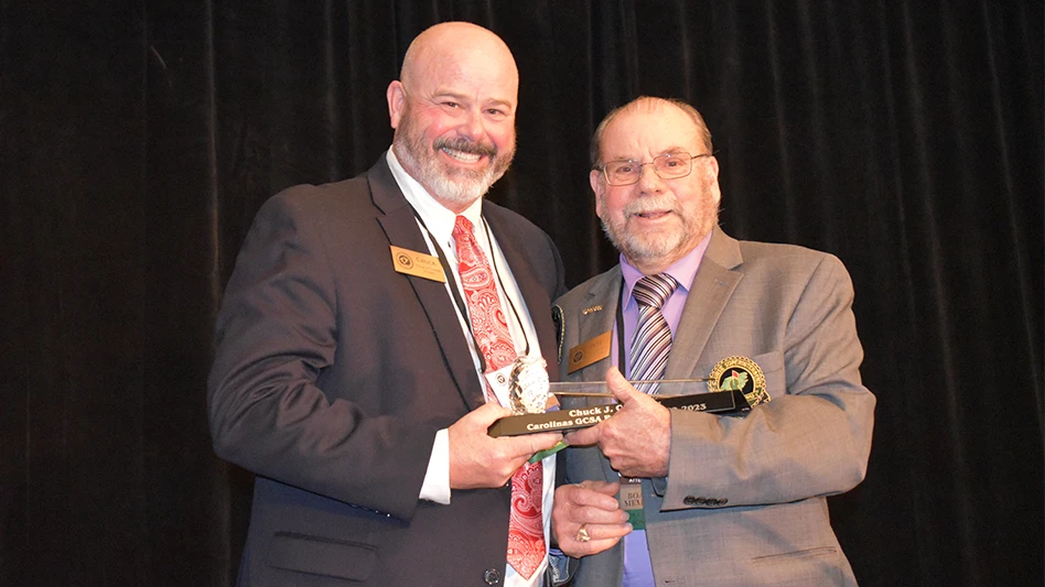 Outgoing Carolinas GCSA President Chuck Connolly accepts a gavel as a memento of his year in office from new President Pete Gerdon.
