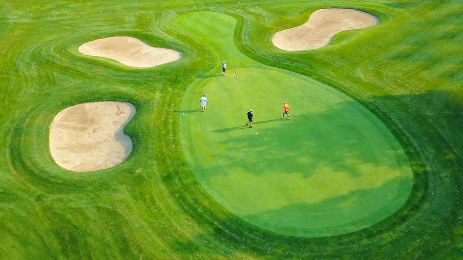 An aerial shot of golfers on a golf green.